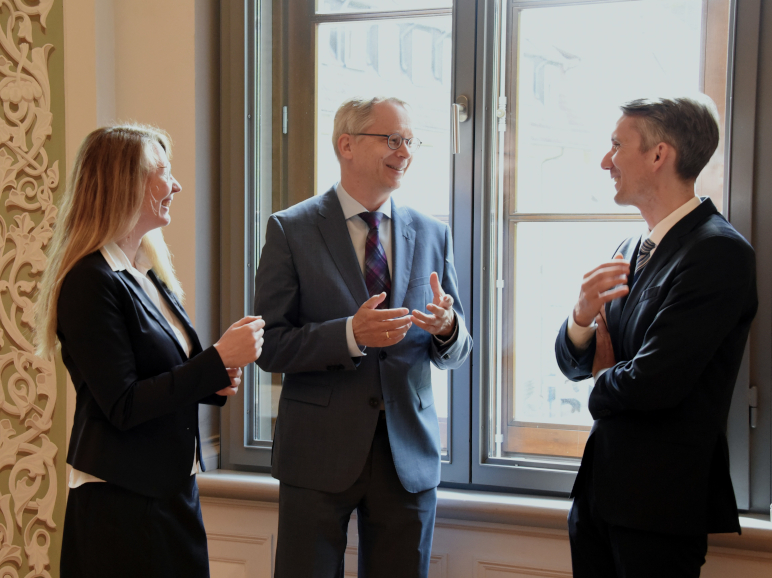von links nach rechts, Richterin Fiala, Richter Endler und Richter Lasch stehen in einer Unterhaltung vertieft vor einem Fenster im Plenarsaal des Oberlandesgerichts Celle