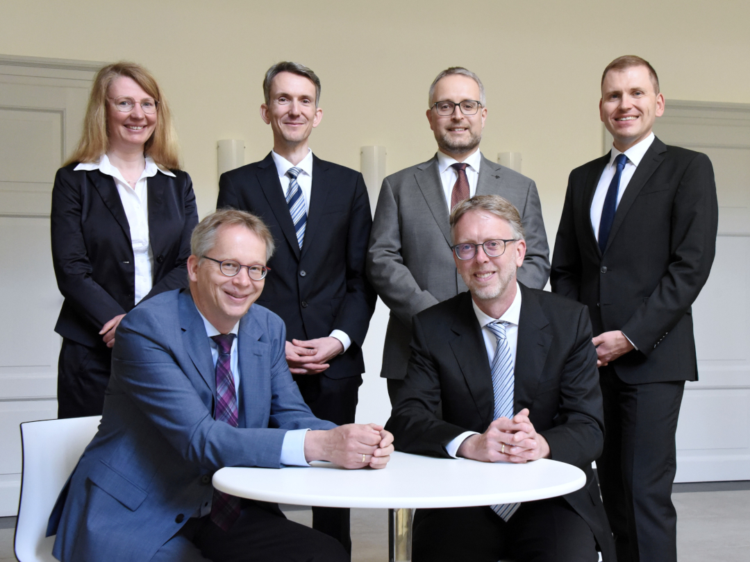 Senate_Commercial_Court_Celle Die beiden Senate mit sechs Personen, fotografiert, im Flur vor dem Innenhof des Oberlandesgerichts Celle.